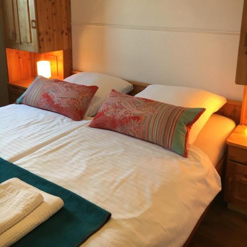 a bed with two pillows on top of it at Landgasthof Waabs Mühle in Waabs