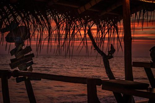 a sunset on the beach with a hammock at Backpack Beach Hostel & Reggae Bar in Galle