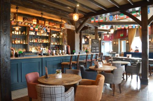 a restaurant with tables and chairs and a bar at The Royal Oak in Woodford