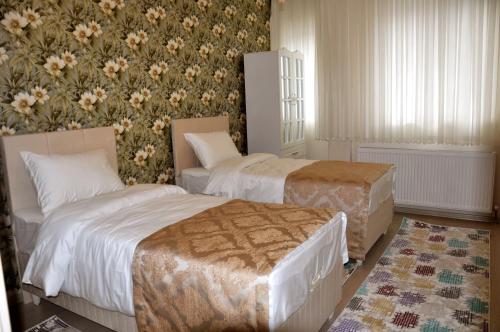 a hotel room with two beds and a floral wallpaper at Şar Pansiyon in Istanbul