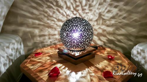 una lámpara en una mesa de madera con corazones. en Riad Gallery 49 en Marrakech