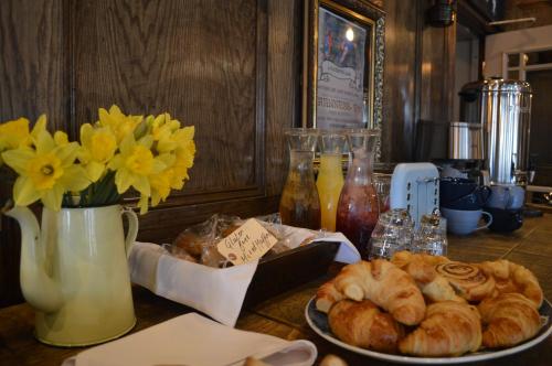 a table topped with a plate of pastries and flowers at The Royal Oak in Woodford