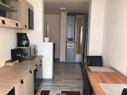 a small kitchen with a table and a microwave at Boulevard Apartment in Oradea