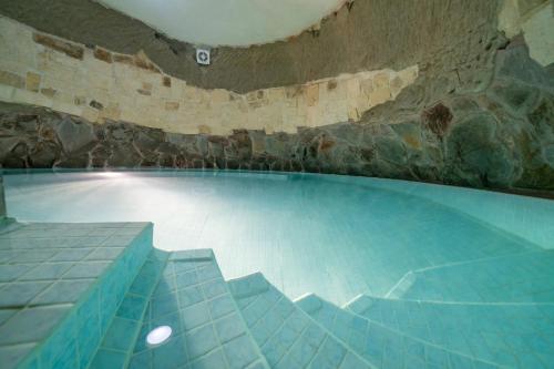 a large swimming pool with a stone wall at Ta Pinu Guesthouse in Għarb