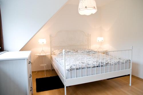 a bedroom with a white bed and two lamps at Zum Fuchsbau in Niederhövels