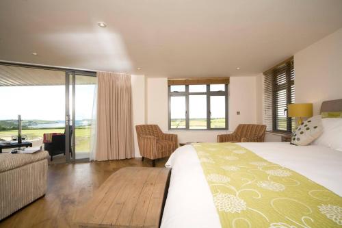 a bedroom with a large bed and a living room at The Pickwick Inn & Oliver's Restaurant in Padstow