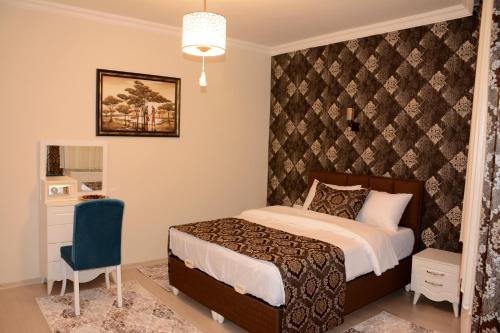 1 dormitorio con cama y pared en Şar Apartment Suites, en Estambul