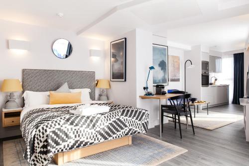 a bedroom with a black and white bed and a desk at Rockwell East-Tower Bridge in London