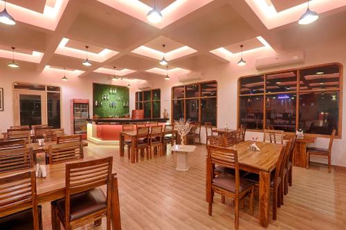 a dining room with wooden tables and chairs at The Byke Old Anchor Beach Resort & Spa in Cavelossim