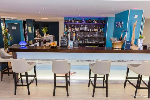 a bar in a hotel with chairs around it at Logis Hôtel du Large in Plougonvelin