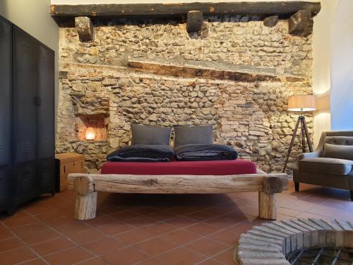 Bett in einem Zimmer mit einer Steinmauer in der Unterkunft Brunnenschmiede in Konstanz