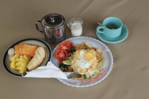 einen Teller Essen auf einem Tisch mit einer Schüssel Essen in der Unterkunft Surya Homestay in Selemadeg