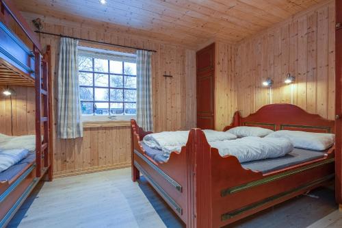 a bedroom with two bunk beds and a window at Knuts Hyttegrend in Beitostøl