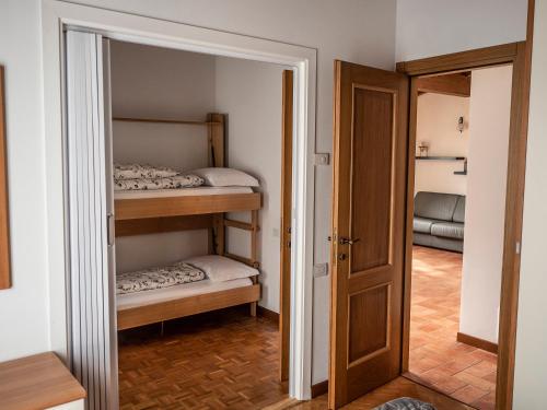 トレモージネ・スル・ガルダにあるCà del Garìの二段ベッド2台とドアが備わる小さな客室です。