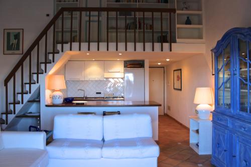 ein Wohnzimmer mit einer weißen Couch und einer Treppe in der Unterkunft Casa vacanze il Corbezzolo - Golfo di Marinella in Porto Rotondo