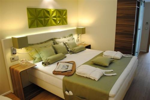 una camera da letto con un grande letto con cuscini verdi di Golfhotel Rheine Mesum a Rheine