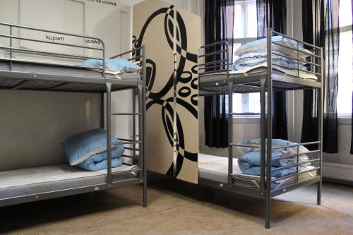 a room with three bunk beds with blue pillows at Globalhagen Hostel in Copenhagen