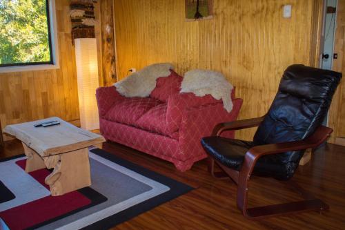 a living room with a couch and a chair at Rincón del Gaucho in Hornopiren
