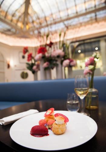 a plate of food on a table with a glass of wine at Hôtel Vernet Champs Elysées Paris in Paris