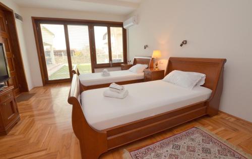 a bedroom with two beds and a television at Mladenovic apartments in Kladovo