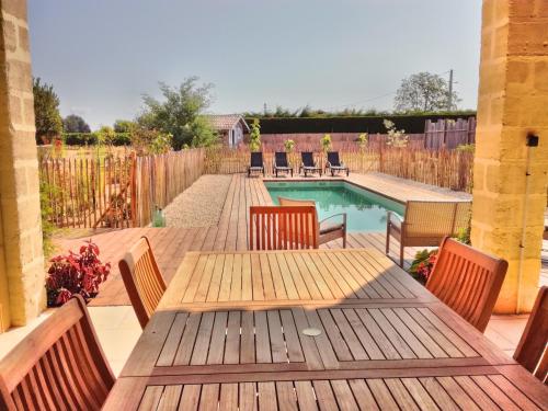 un patio avec une table et des chaises et une piscine dans l'établissement Villa l'Estuaire Chambres d'Hôtes, à Braud-et-Saint-Louis