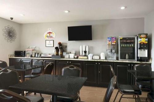 a restaurant with a bar with tables and chairs at Super 8 by Wyndham Ardmore in Ardmore