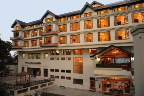 a large white building with many windows at Club Mahindra Mashobra in Mashobra