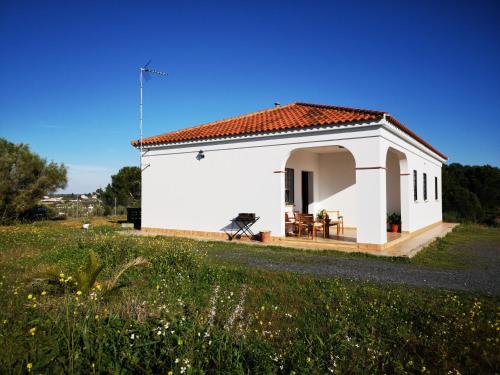 een klein wit gebouw met een grasveld bij Casa Rural Cerca de la Playa El Rompido in El Rompido