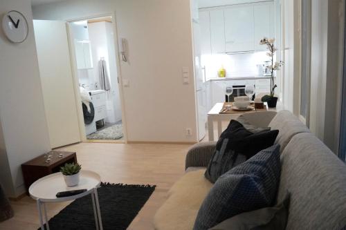 a living room with a couch and a table at Studio in Trendy Kakola Hill area close to city center in Turku