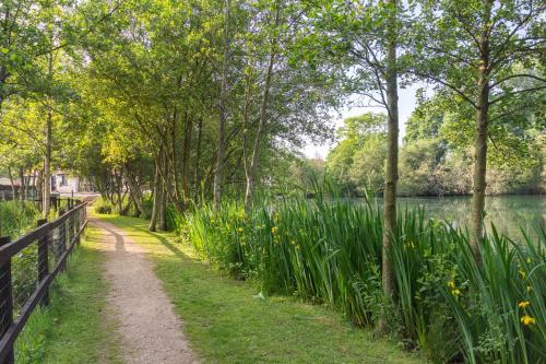 a path next to a fence next to a lake at The Lakes Rookley in Rookley