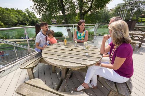 a group of people sitting around a wooden table at The Lakes Rookley in Rookley