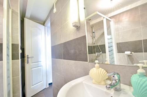 une salle de bain avec un lavabo et un miroir dans l'établissement Duplex des 13 Cantons, à Marseille
