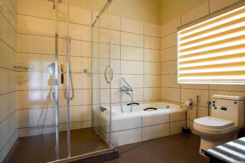 a bathroom with a shower and a sink and a toilet at Alencherry plantation homestay in Thekkady