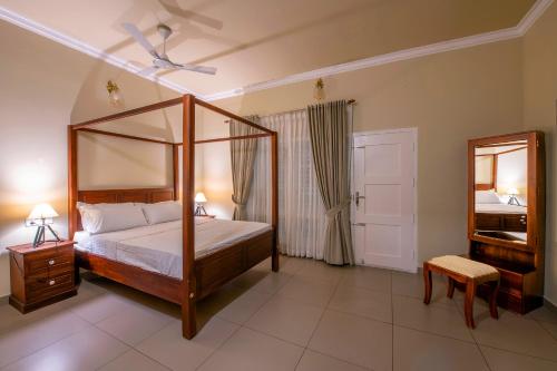 a bedroom with a canopy bed and a mirror at Alencherry plantation homestay in Thekkady