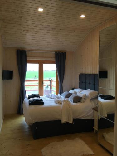 1 dormitorio con 2 camas y ventana grande en The Orchard Bramble Lodge, en Hadleigh