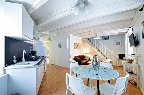 une cuisine et un salon avec une table et des chaises dans l'établissement Appartement du Palais Longchamps, à Marseille