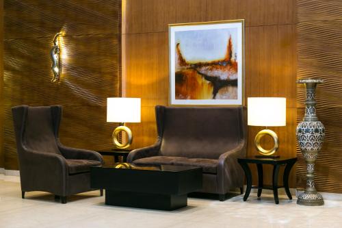a living room with two chairs and a vase at Babylon Rotana Hotel in Baghdād
