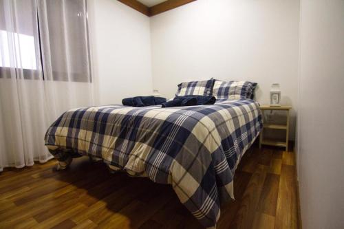 AlfeizerãoにあるQuintinha da Charnecaのベッドルーム1室(青と白の毛布付きのベッド1台付)