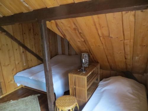 an attic room with two bunk beds and a stool at Sodyba Brazylija in Taraldžiai
