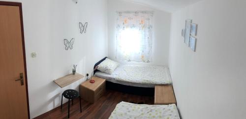 a small room with a bed and a window at Andrija Apartment in Krnica