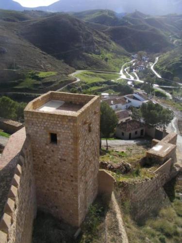 an old brick building on a hill with a winding road at LA ATALAYA GREAT LUXURY ATTIC in Antequera