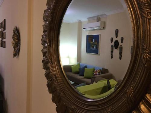 a mirror in a living room with a couch at Pool View Apartment At British Resort Unit 221 in Hurghada