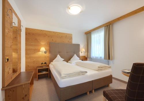una camera d'albergo con letto e scrivania di Garni Lanzinger a Selva di Val Gardena