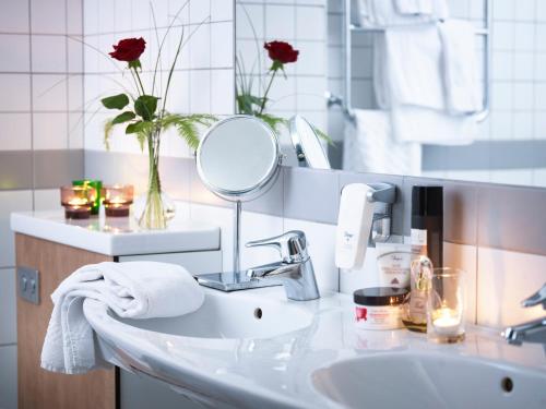 La salle de bains est pourvue d'un lavabo et d'un miroir. dans l'établissement Hotel Terraza, à Ljungby