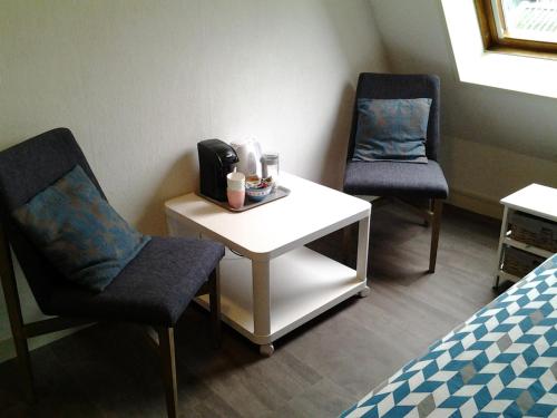 a room with two chairs and a table and a bed at Bed & Breakfast Meinsma in Moddergat