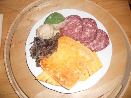 a plate of food with meat and meats on a table at Rifugio Pranolz in Trichiana