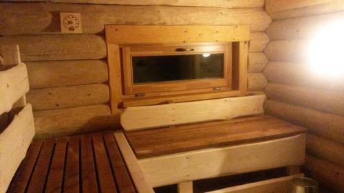 a room with a tv in a log cabin at Ezerkalni in Raiskums