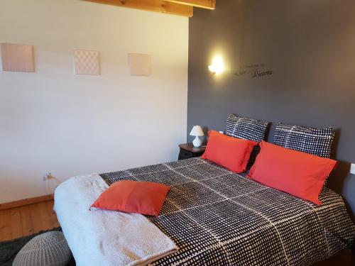 Un dormitorio con una cama con almohadas rojas. en La Tannerie du Port, en Dinan