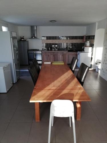 a wooden table and chairs in a kitchen at Maison d'hôtes Le Jas Vieux in Montfort