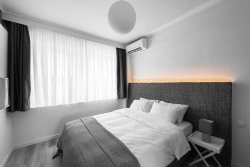 sypialnia z dużym łóżkiem i oknem w obiekcie M&F Luxury Suites est. 2019 / F Suite w Salonikach
